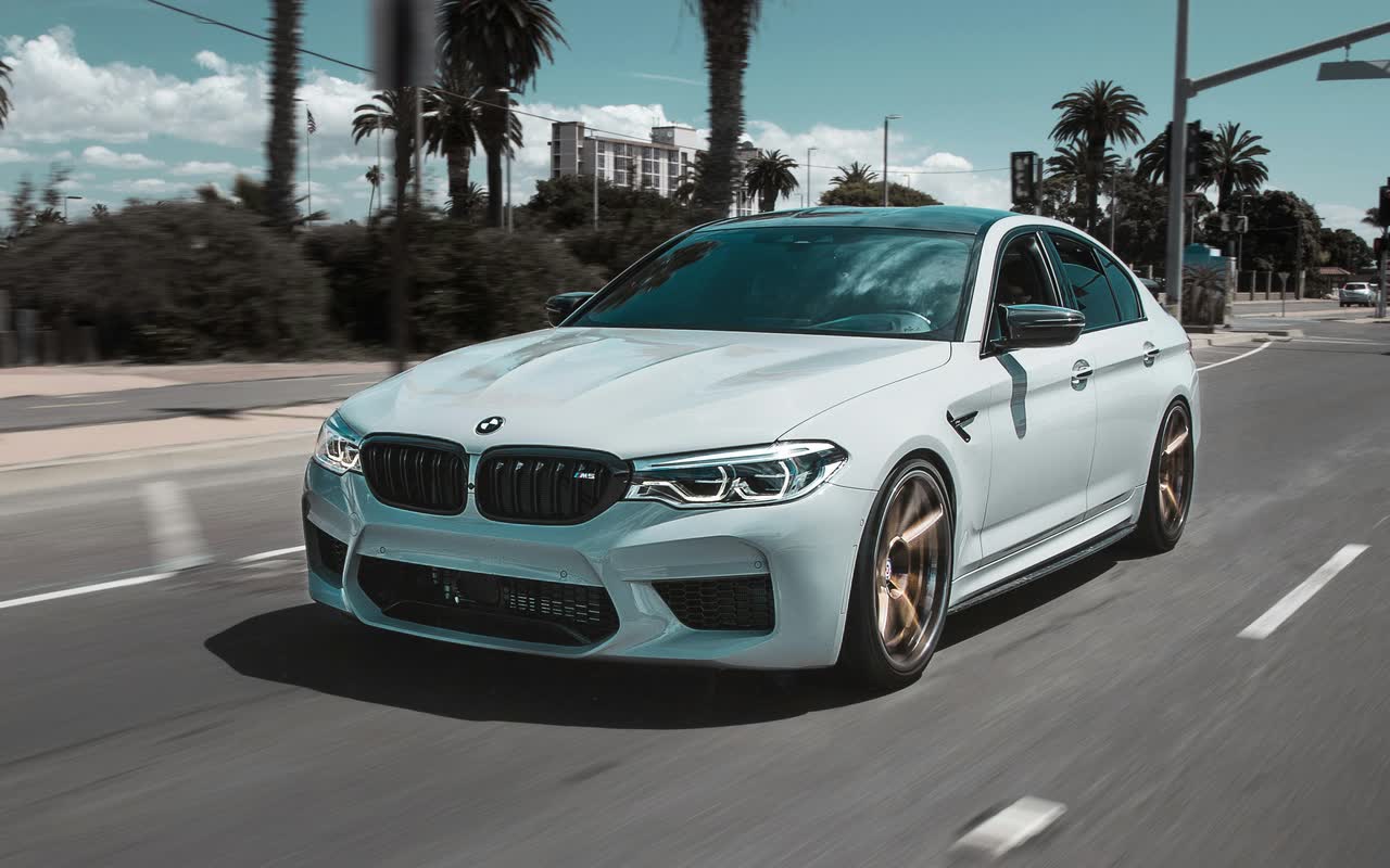Белый BMW M5 на городской дороге